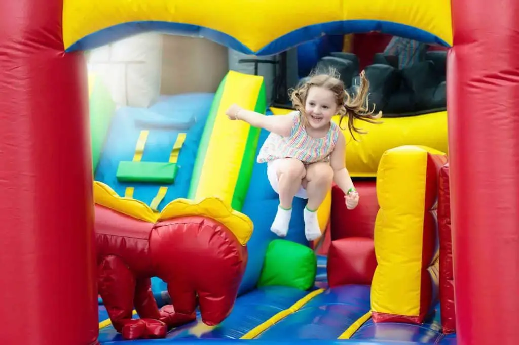Foto di una bambina che gioca su un castello gonfiabile