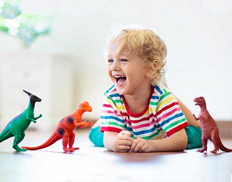 bambino di 4 anni felice di giocare con i dinosauri