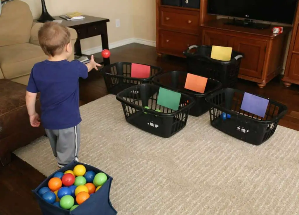 bambino lancia le palline colorate dentro i cesti