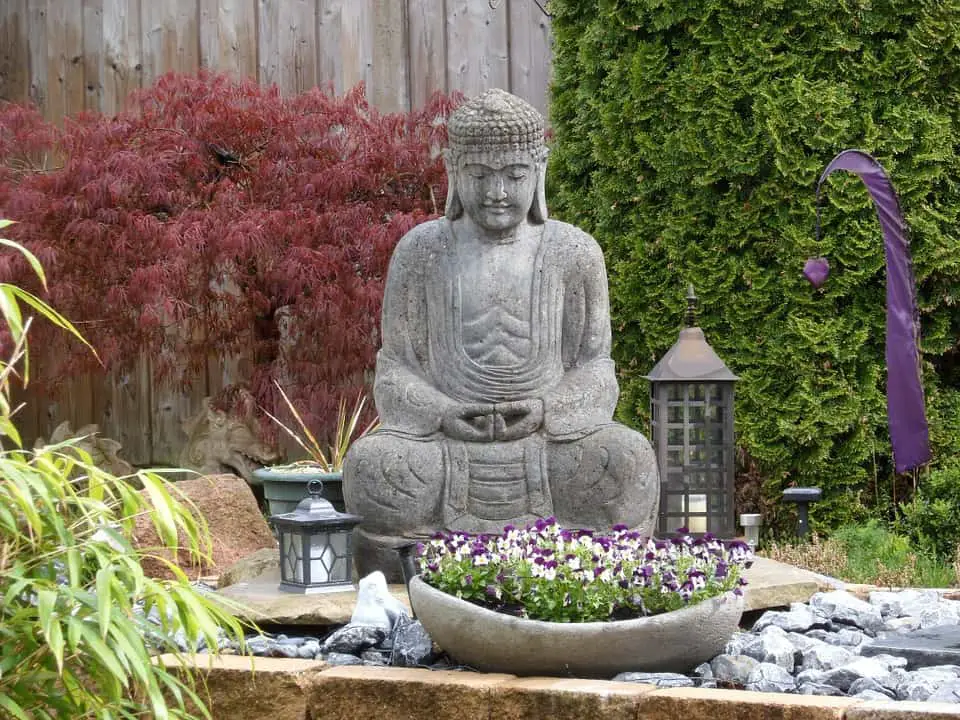 statua di Buddha davanti a dei fiori