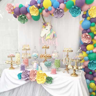 festa tema unicorno - allestimento tavola con fiori di carta multicolore