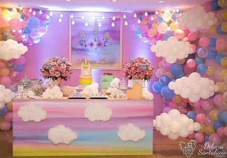 festa tema unicorno - allestimento tavola con nuvole di palloncini e fila di lampadine