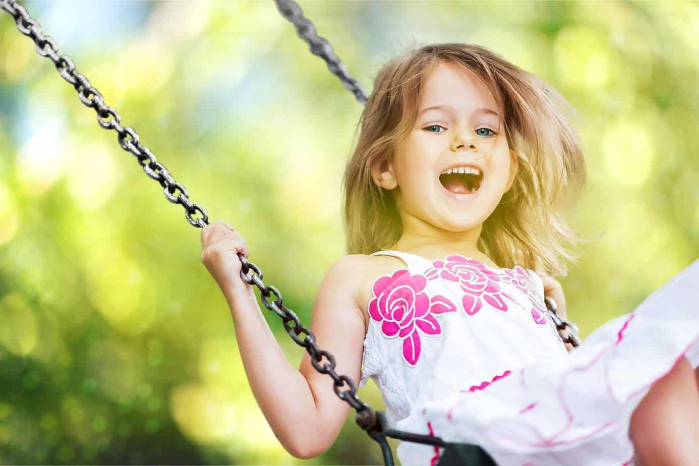 Foto di bambina che gioca su un'altalena
