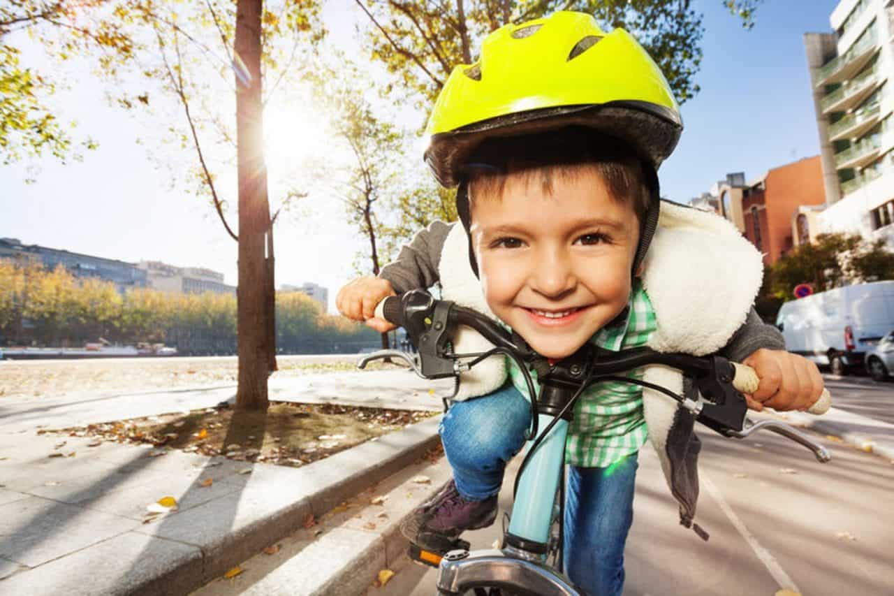 Bambino in bicicletta sorride