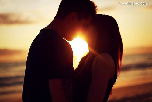 coppia di innamorati si bacia al tramonto