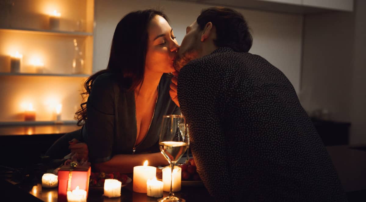 coppia si bacia durante cena romantica a san valentino