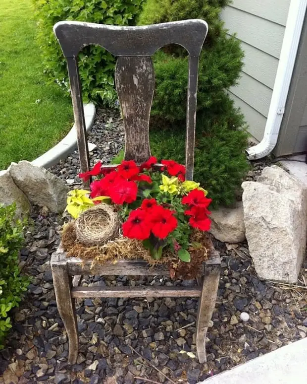 vecchia sedia con fiori per abbellire il giardino