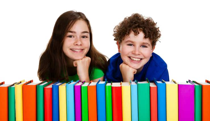 Bambini di 11 anni dietro una pila colorata di libri