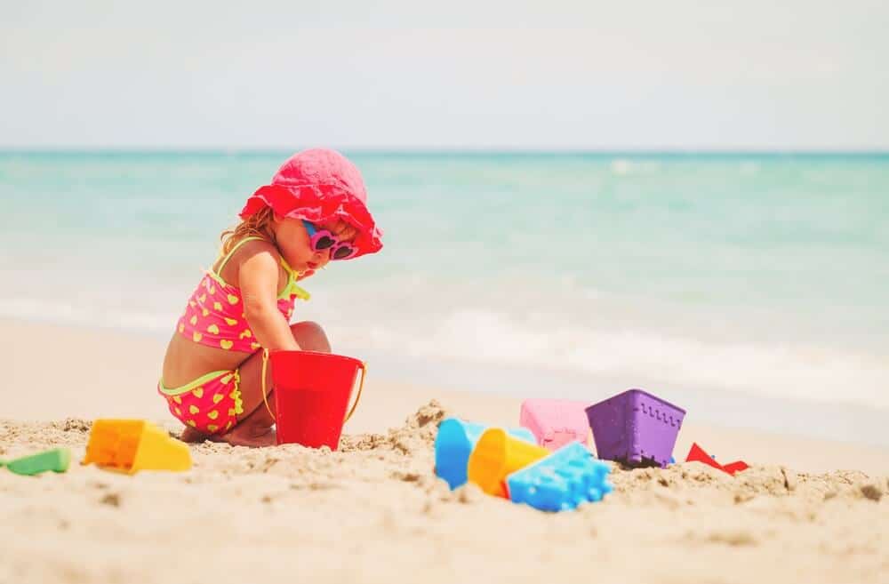 Bambina gioca sulla sabbia