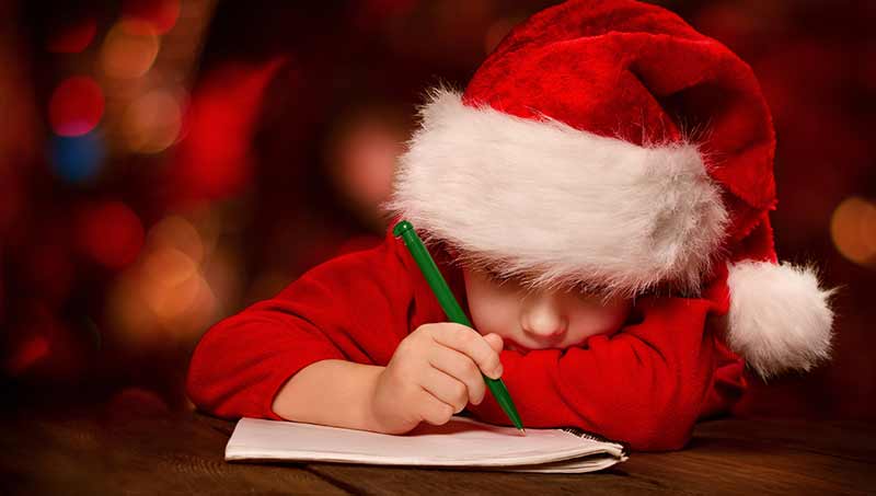 bambino scrive letterina a Babbo Natale