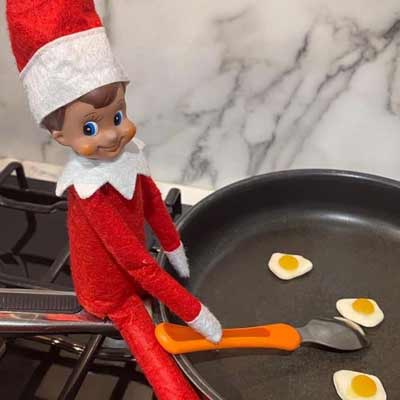 elfo sulla mensola che cucina le uova
