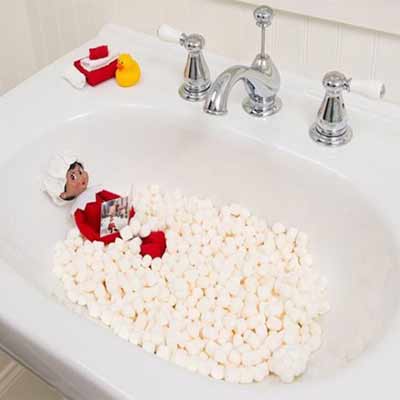 elfo sulla mensola che fa il bagno nel rubinetto con i marshmallow